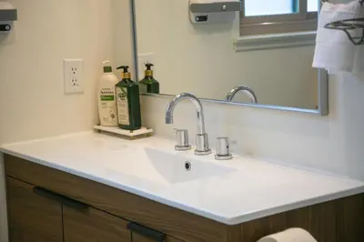 a bathroom sink with two bottles of alcohol on it at 20 min to Disneyland - Spacious Family Home Near All the Fun in Westminster