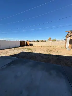 a large yard with a fence and a building at Welcome to A new updated 3 bedroom 2 Bath Home in California City