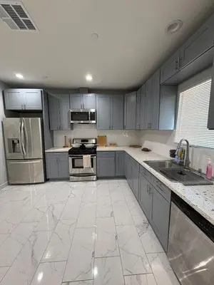 a large kitchen with gray cabinets and stainless steel appliances at Welcome to A new updated 3 bedroom 2 Bath Home in California City