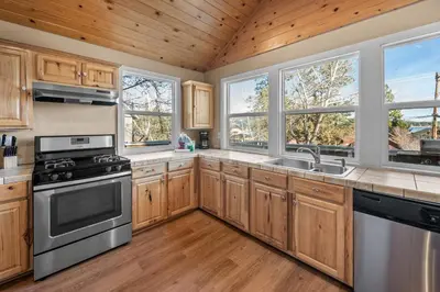 a kitchen with wooden cabinets and stainless steel appliances at Appleview - Walk to Village/Lake, Lake View, Hot Tub, BBQ in Big Bear Lake