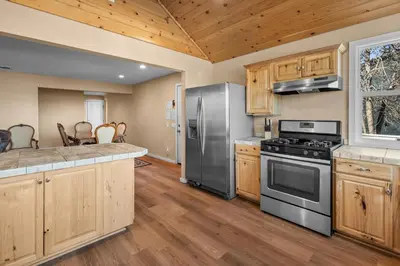 a kitchen with stainless steel appliances and wooden cabinets at Appleview - Walk to Village/Lake, Lake View, Hot Tub, BBQ in Big Bear Lake