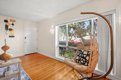 a living room with a chair and a large window at Steps to the Beach - Games - Free Parking in Long Beach