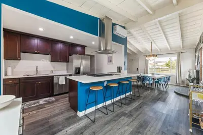 a kitchen with a blue island with bar stools at Casa Verde in Inglewood
