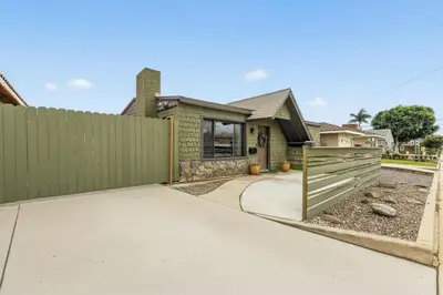 a green house with a fence and a driveway at Casa Verde in Inglewood