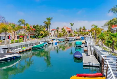 a group of boats docked in a river with houses at Steps to Beach - Beach Essentials Provided! in Long Beach