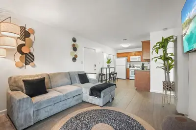 a living room with a couch and a kitchen at Steps to Beach - Beach Essentials Provided! in Long Beach