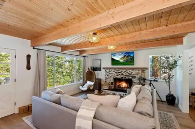 a living room with a couch and a fireplace at Yama Cabin - 5 min walk to the village, EV plug, hot tub, kid & pet friendly in Lake Arrowhead