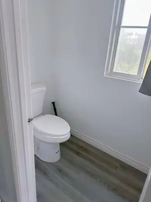 a white bathroom with a toilet and a window at Big master bedroom private bathroom in Fontana