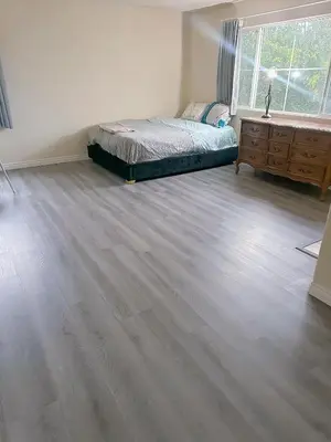 a bedroom with a bed and a dresser and a wooden floor at Big master bedroom private bathroom in Fontana