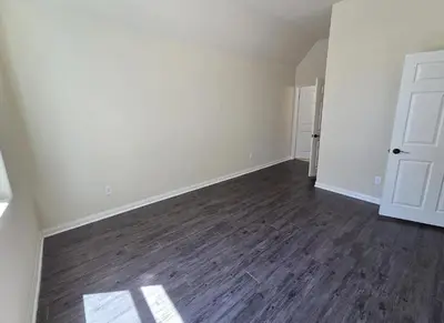 an empty room with white walls and wood floors at Woodland Oasis 2BR With FREE PARKING in Canoga Park