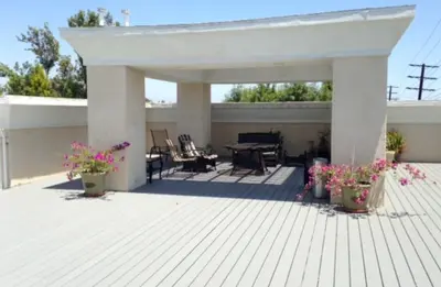 a patio with a table and chairs and flowers at Woodland Oasis 2BR With FREE PARKING in Canoga Park