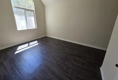 an empty room with a wooden floor and a window at Woodland Oasis 2BR With FREE PARKING in Canoga Park