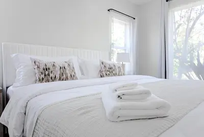 a white bed with white towels on top of it at Modern 5 Bed with Guest House & Pool West Hollywood in Los Angeles