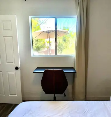 a room with a window with a chair and an umbrella at Stunning Oasis with Pool by Disneyland and Knotts in Buena Park