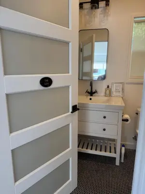 a bathroom door with a sink and a mirror at NEW Cozy Studio City Guesthouse in Prime Location in Studio City
