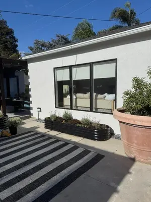 a white house with black windows and plants at NEW Cozy Studio City Guesthouse in Prime Location in Studio City