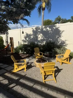 a group of yellow chairs sitting around a fire pit at NEW Cozy Studio City Guesthouse in Prime Location in Studio City