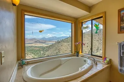 a large tub in a bathroom with a large window at Camp David in Wofford Heights