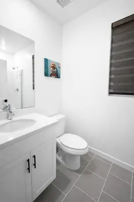 a white bathroom with a toilet and a sink at 85 hotel in Eastvale
