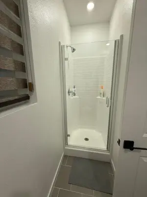 a shower with a glass door in a bathroom at 85 hotel in Eastvale