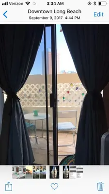a window with curtains in front of a beach at Ocean Condo Penthouse with Gym & Parking in Long Beach