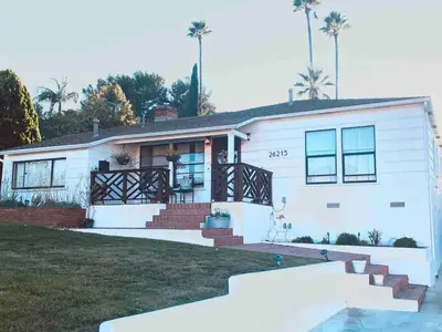 a white house with palm trees in the background at 2BR LA Beach City House With Gym & Tesla Charging in Harbor City