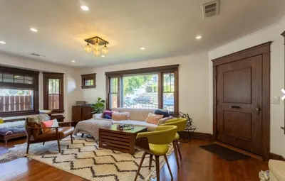 a living room with a couch and a table and chairs at Historical Craftsman with Modern Amenities in Los Angeles