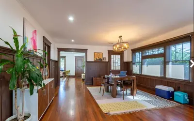 a dining room with a table with a laptop on it at Historical Craftsman with Modern Amenities in Los Angeles