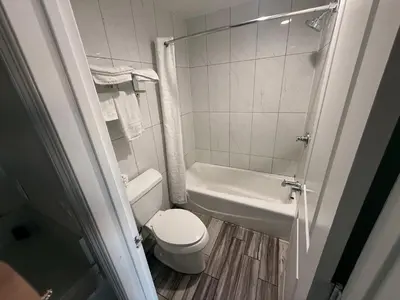 a small bathroom with a toilet and a sink at Crescent Motel, South Gate - Los Angeles in South Gate