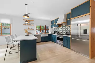 a kitchen with blue cabinets and a refrigerator at Luxury 4BR Villa with Private Pool in Los Angeles Crescent Heights in Los Angeles