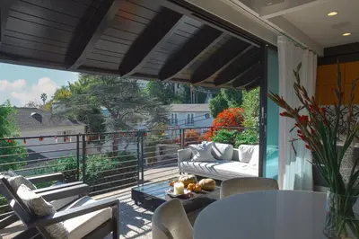 a patio with a couch and chairs on a balcony at 2BR Luxury Villa in West Hollywood with Private Pool in Los Angeles