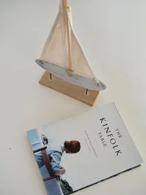 a book with a model of a sail boat on it at Exquisite Carpinteria Beach Cottage, Steps Away From The Beach in Carpinteria