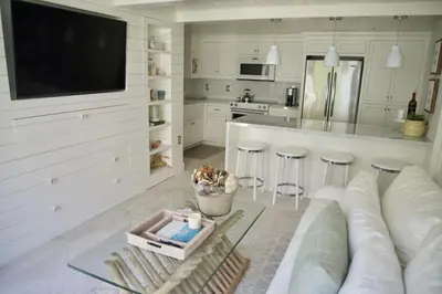 a white kitchen with a couch and a counter at Exquisite Carpinteria Beach Cottage, Steps Away From The Beach in Carpinteria