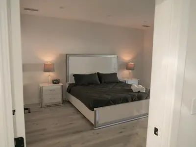 a bedroom with a bed with two night stands and two lamps at Sleek 7BR Exquisite Estate Resort Pool, Sauna, Spa 6500 SQF in Woodland Hills