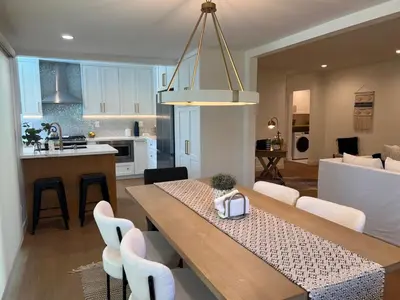 a kitchen and living room with a table and chairs at Quintessential SoCal indoor outdoor living with POOL in Long Beach