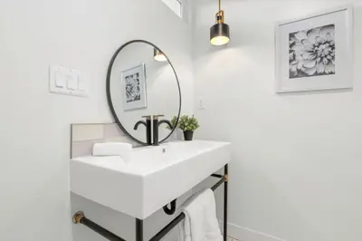 a bathroom with a white sink and a mirror at Quintessential SoCal indoor outdoor living with POOL in Long Beach