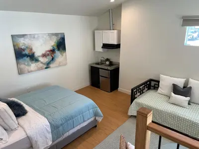 a bedroom with a bed and a kitchen in it at Quintessential SoCal indoor outdoor living with POOL in Long Beach