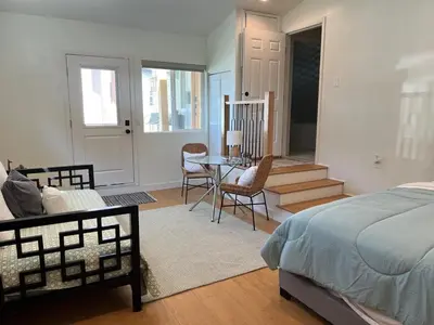 a bedroom with a bed and a table and chairs at Quintessential SoCal indoor outdoor living with POOL in Long Beach