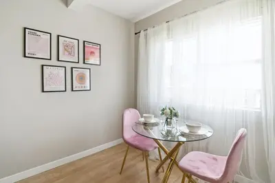 a dining room with a glass table and pink chairs at Sunny Santa Monica Retreat, Walk to Beach in Santa Monica