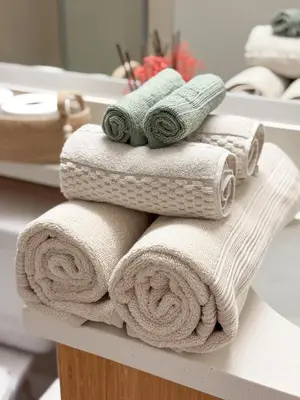 a pile of towels on a shelf in a bathroom at Sunny Santa Monica Retreat, Walk to Beach in Santa Monica