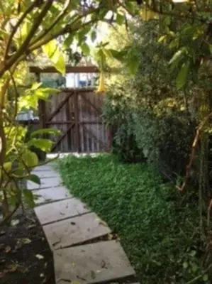 a garden with a walkway with green grass and a fence at Venice Beach House with beautiful private yard in Los Angeles