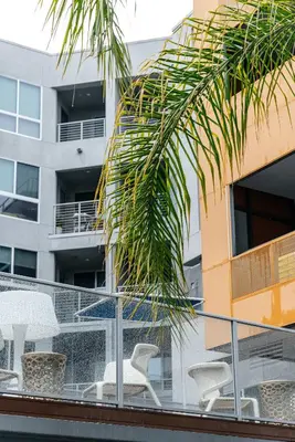 a balcony with chairs and a palm tree on a building at West Hollywood Luxe Townhome Walkable WeHo Avalon in Los Angeles
