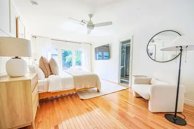 a bedroom with a bed and a chair and a mirror at Chic 6BR West Hollywood Villa with Jacuzzi in Los Angeles