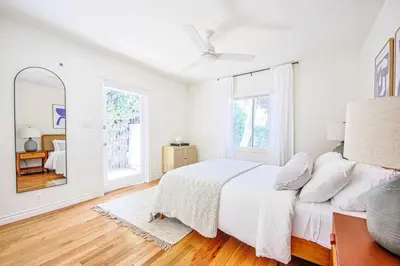 a white bedroom with a bed and a mirror at Chic 6BR West Hollywood Villa with Jacuzzi in Los Angeles