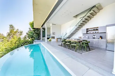 an open kitchen and dining room with a pool in a house at Hillside 4B Villa w Infinity Pool City Views in Los Angeles