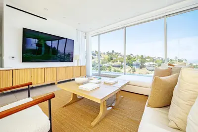 a living room with a table and a large window at Hillside 4B Villa w Infinity Pool City Views in Los Angeles