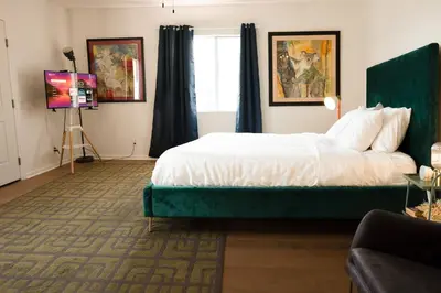 a bedroom with a bed with a green headboard at Curated Central Location LA in Los Angeles