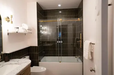 a bathroom with a shower with a tub and a toilet at Curated Central Location LA in Los Angeles