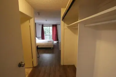 a hallway with a room with a bed and a window at Cozy Beverly Hills Hotel Style apartment in Los Angeles