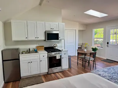 a kitchen with white cabinets and a sink and a table at Skylight Terrace in Los Angeles